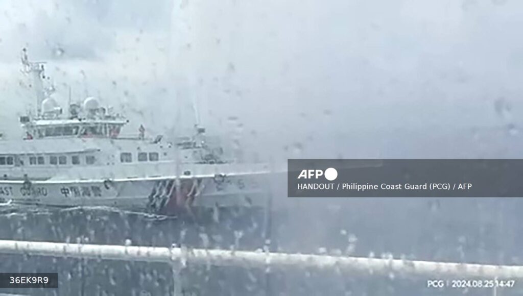 This frame grab from handout video footage taken and released on August 25, 2024 by the Philippine Coast Guard (PCG) shows a Chinese coast Guard ship (L) using water cannon against the Philippine Bureau of Fisheries and Aquatic Resources (BFAR) vessel BRP Datu Sanday, near Sabina Shoal in disputed waters of the South China Sea. - China's coast guard said it rescued Filipino "personnel" who fell overboard August 25 after a Philippine vessel collided with one of its ships near a disputed shoal in the South China Sea.