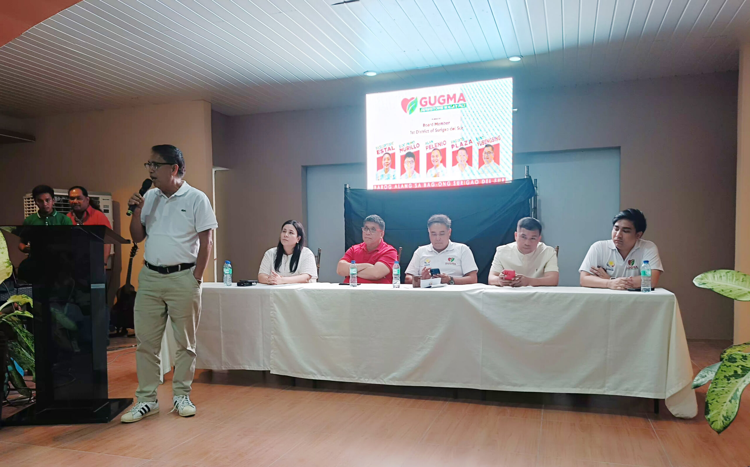 Gugma Surigao del Sur provincial board member aspirant Eddie Istal, former president of Northeastern Mindanao State University, speaks while top party bets, including former 1st District Rep. Prospero Pichay, listen during a gathering in San Agustin town on Oct. 9, 2024. 