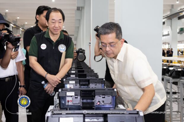 (From left) Parish Pastoral Council for Responsible Voting national coordinator Arwin Serrano and Commision on Elections chairman George Erwin Garcia oversees the "stress testing" of automated counting machines for the upcoming 2025 elections at a warehouse in Biñan, Laguna on Wednesday, November 13, 2024. INQUIRER.net/John Eric Mendoza